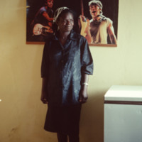 Unidentified Woman, Indoors, Vila do Maio, with Concert Poster